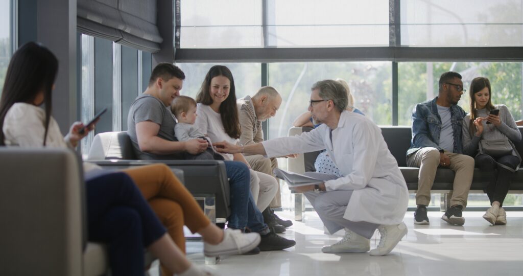 Doctor talks to family with little child in clinic waiting room